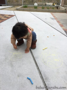 庭で落書きをする子供